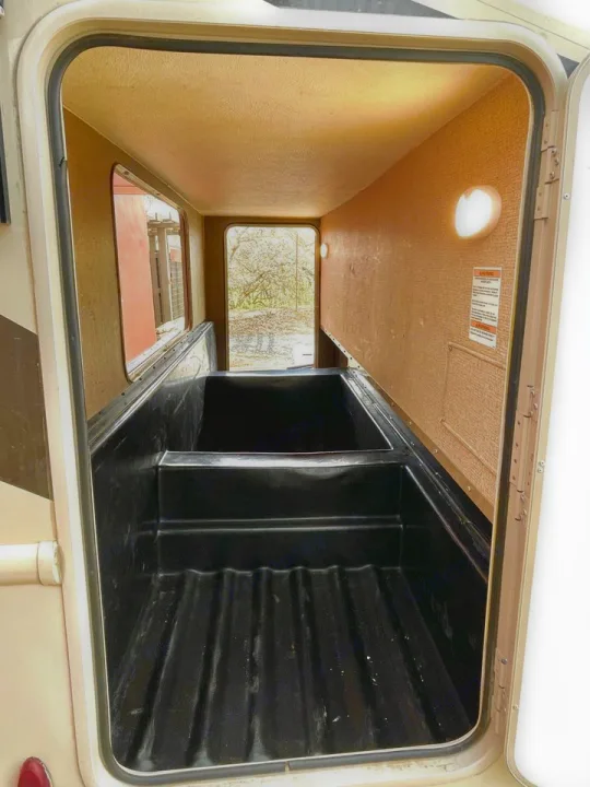 Large, empty, and clean pass-through storage compartment of an RV rental, well-lit and ready for your trip.. Thor Motor Coach Chateau Sprinter 2018