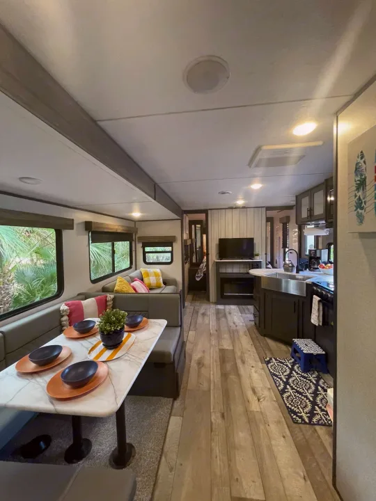 Bright RV rental interior with spacious dining, comfy lounge, and modern kitchen. Ideal for a cozy travel stay.. Dutchmen Aspen Trail 2022