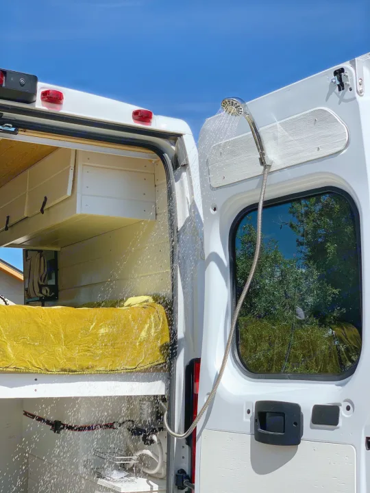 Experience mobile living convenience! This RV rental features an outdoor shower from its rear doors, perfect for van life.. Dodge Promaster 2500 2021