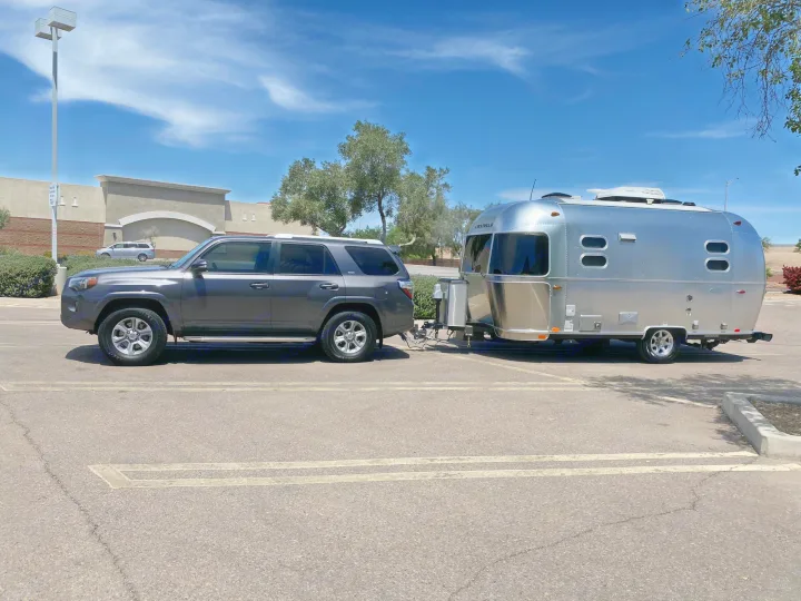 RV rental adventure begins! A silver Airstream travel trailer hitched to a dark SUV in a sunny parking lot.. Airstream Flying Cloud 2018