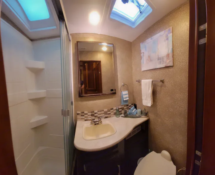 Well-equipped RV rental bathroom with a spacious shower, sink, toilet, and skylights, ensuring comfort on the road.. Jayco Eagle 2016