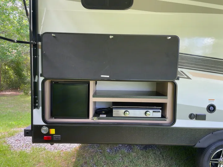 RV rental outdoor kitchen: a mini-fridge and a Greystone gas stove within a convenient exterior compartment.. Cruiser Rv Corp Radiance 2022