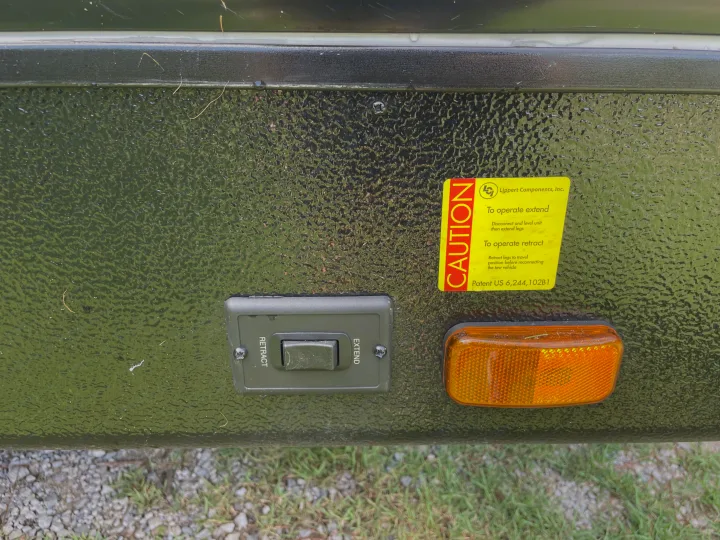 An RV rental's leveling leg control panel featuring "Retract" and "Extend" buttons, and a yellow "Caution" sticker.. Cruiser Rv Corp Radiance 2022