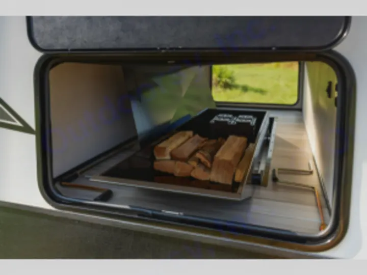 This RV rental's accessible storage bay features a pull-out tray with firewood, perfect for outdoor camping adventures.. Cruiser Rv Corp Radiance 2022