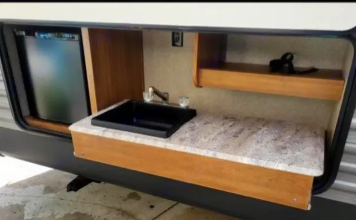 Explore this RV rental's convenient outdoor kitchen with a mini-fridge, sink, and counter space for your travels.. Coachmen Catalina 2019