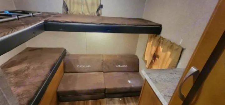 RV rental interior features multiple bunk beds and a comfortable Catalina sofa, optimizing compact space for travel.. Coachmen Catalina 2019