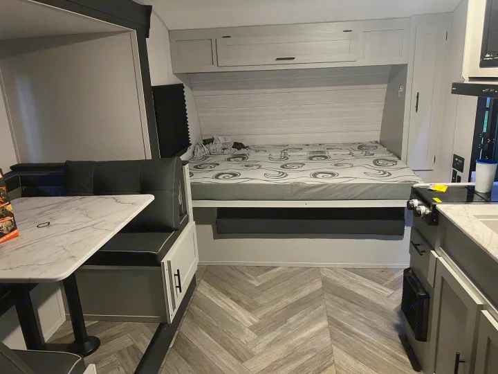Spacious RV rental interior with bed, dinette, and kitchen. Ideal for comfortable camper trips.. Forest River Salem FSX 2022