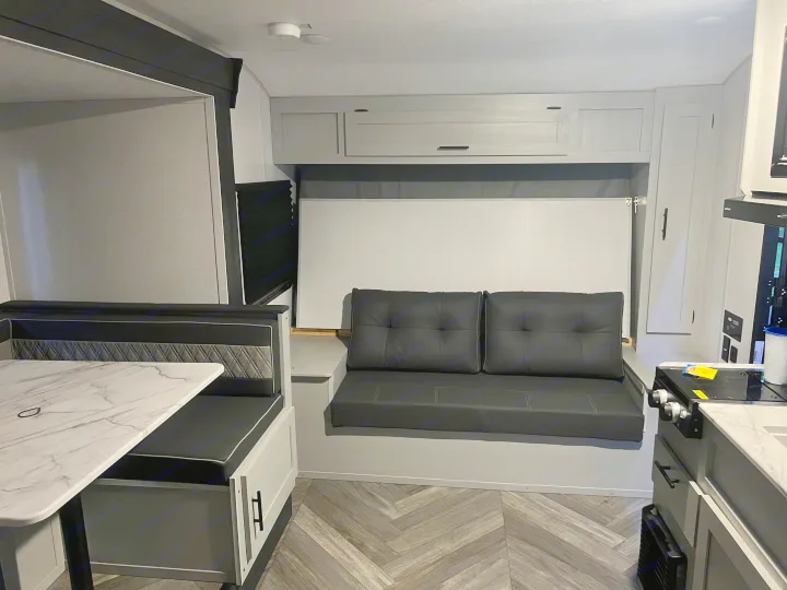 Spacious, modern RV rental interior featuring a dinette, convertible sofa bed, and kitchen essentials for comfortable travel.. Forest River Salem FSX 2022