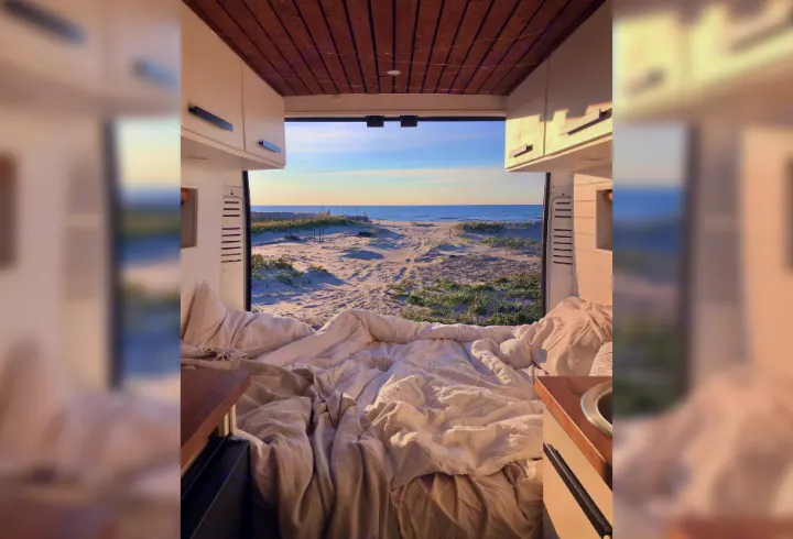 Experience van life in an RV rental: a cozy bed faces a sandy beach, dunes & ocean. Ideal for serene beach getaways.. RAM Promaster 2500 2017