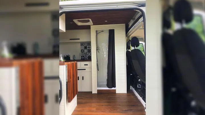 Step inside this RV rental: a modern camper van conversion with a kitchen, full shower, and front seating area.. RAM Promaster 2500 2017
