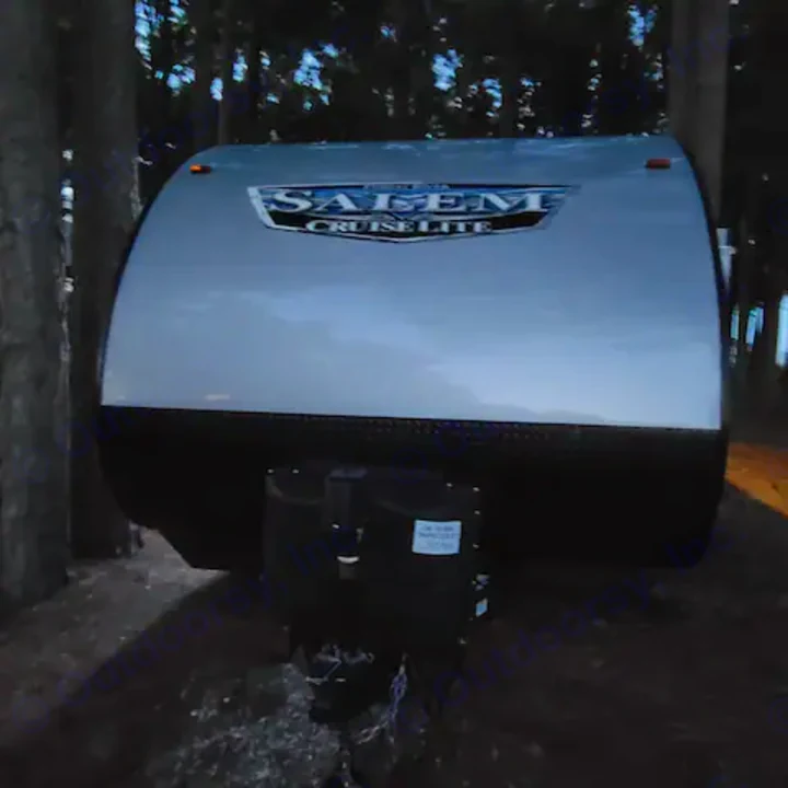Salem Cruise Lite travel trailer, an ideal rv rental for outdoor camping. Parked in a wooded area at dusk.. Forest River Salem Cruise Lite 2022