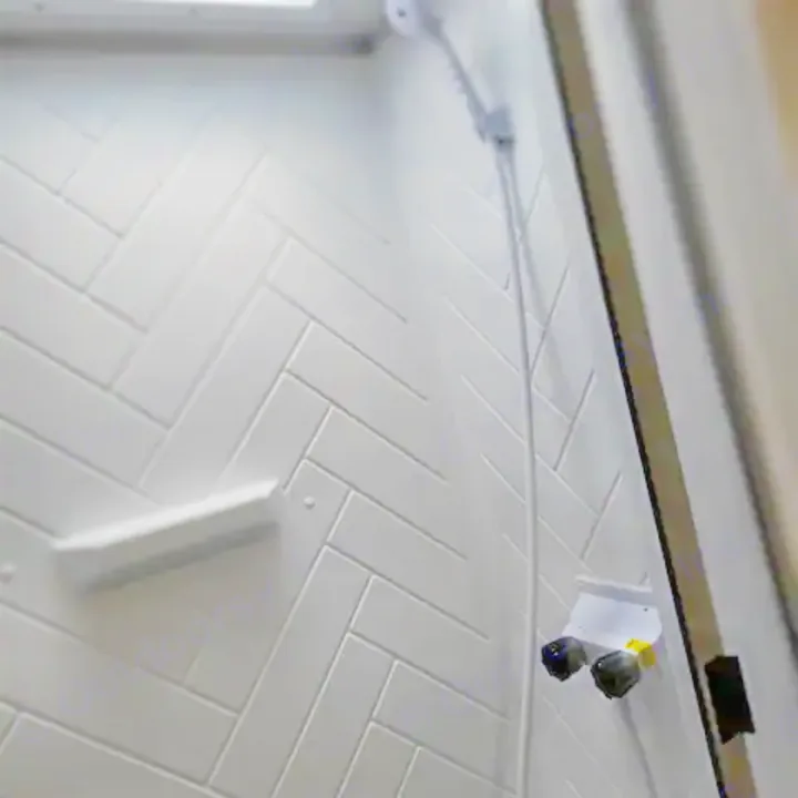 A bright white, compact shower stall in an RV rental, featuring herringbone patterned walls, a small shelf, and a handheld showerhead.. Forest River Salem Cruise Lite 2022