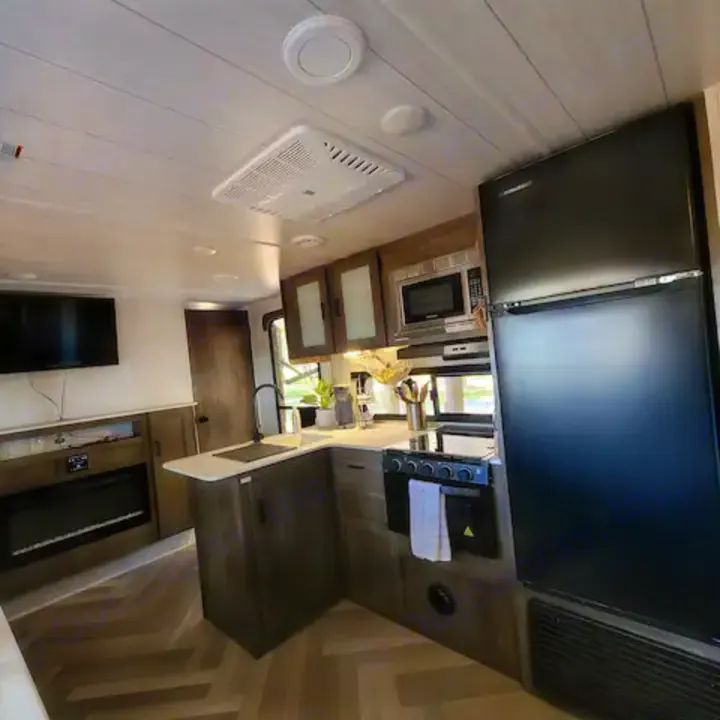 Explore this modern RV rental interior! Features a full kitchen, comfy living area with TV & fireplace. Your adventure awaits!. Forest River Salem Cruise Lite 2022