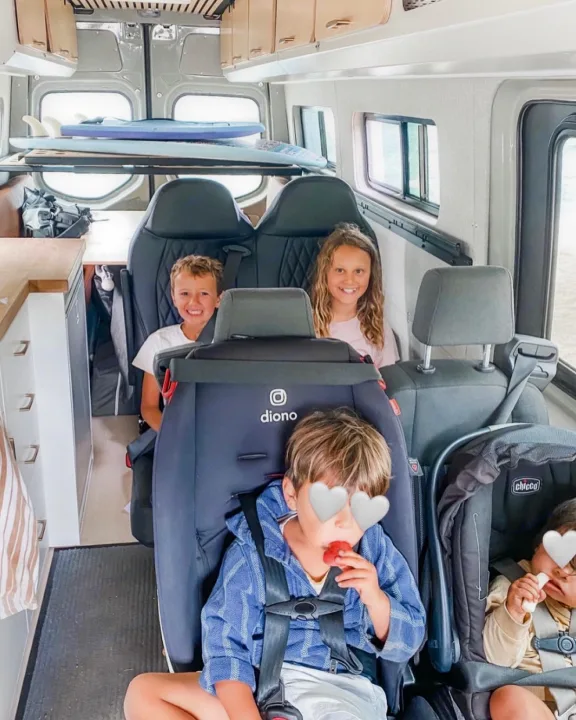 Four kids are ready for adventure in their cozy RV rental, complete with car seats and surfboards stored overhead.. Mercedes Sprinter 2021