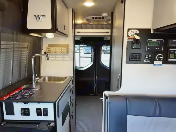 Inside this RV rental, find a compact kitchen with a sink, faucet, and an organized control panel for comfort on the road.. Winnebago Revel 2022