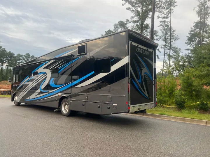 Experience freedom! This striking black Outlaw RV motorhome with blue graphics is ready for your next rv rental journey.. Thor Outlaw 2022