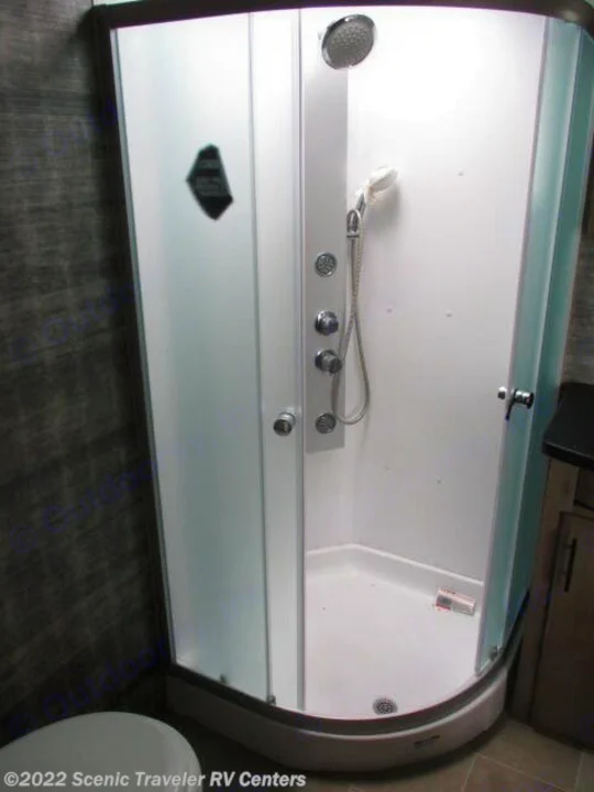 This compact shower unit in an RV rental features clear glass doors, an overhead and handheld showerhead, ideal for travel.. Forest River Vengeance Rogue Armored Toy Hauler 2021