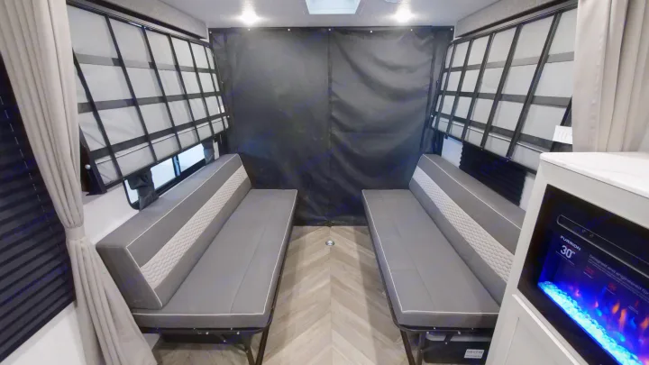 RV rental: View of a versatile toy hauler interior with convertible benches, an electric fireplace, and blinds.. Forest River Wildwood 2022