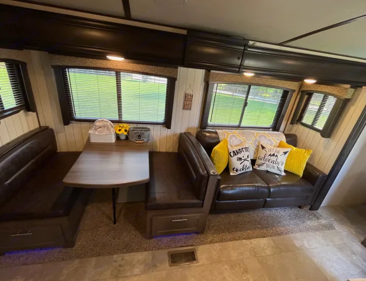 Spacious RV rental interior with a cozy dinette, comfortable sofa, and bright windows, perfect for travel adventures.. Crossroads RV Sunset Trail Super Lite 2018