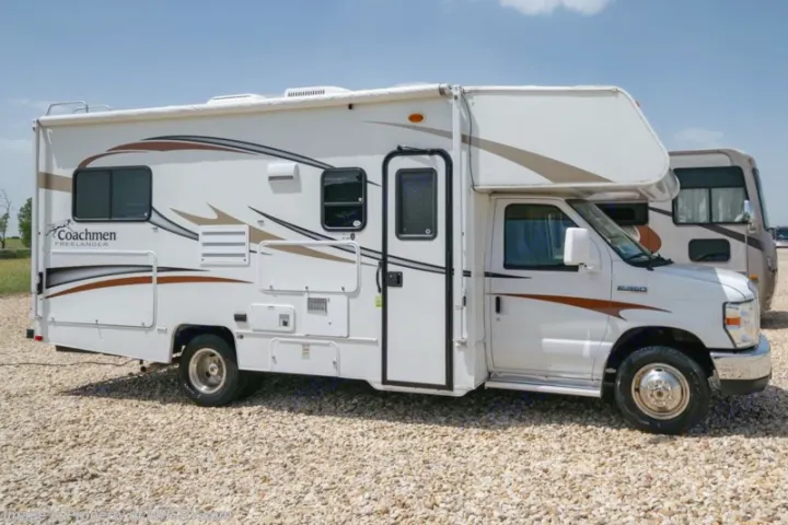 White Coachmen Freelander RV rental, a Class C motorhome, ready for your road trip or camping adventure. Parked on a gravel lot.. Coachmen Freelander 2014