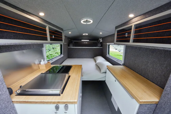Modern RV rental interior with kitchen, bed, & clever storage. Ideal compact living space.. Chevrolet silverado 2500 2022