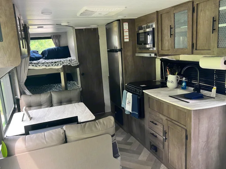 Modern RV rental interior featuring a full kitchen, bunk beds, and a cozy dinette. Ideal for family adventures.. Forest River Salem Cruise Lite 2021