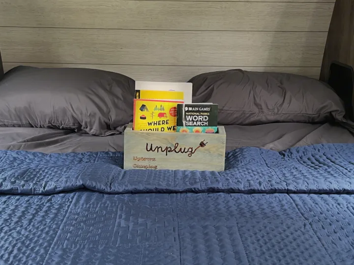 Unplug and enjoy your RV rental! Cozy bed with a box of games like "Where Should We" and "National Parks Word Search" for camping fun.. Forest River Salem Cruise Lite 2021