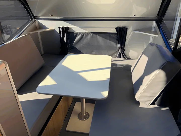 You can set up the table at the back of the trailer to comfortable seat 4 on a rainy day for games and meals!. Safari Condo Alto R1723 Bunkhouse 2022