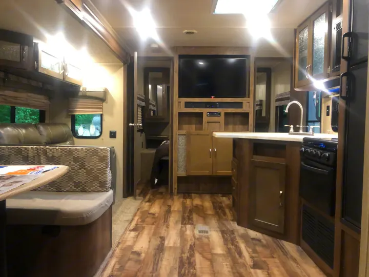 Bright, modern RV rental interior showcasing a spacious living area with kitchen, dinette, and entertainment.. Forest River Palomino Puma 2018