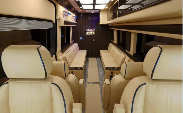 Spacious luxury RV rental van interior: plush cream seating, TV, and elegant amenities for premium travel.. Ultimate Toys Ultimate RV 2023