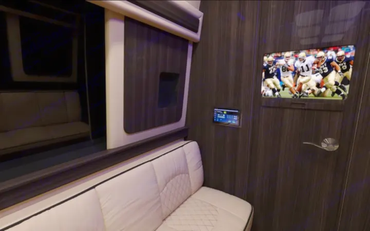Relax in this RV rental's luxury interior, featuring white quilted seating, a flat-screen TV, and smart controls.. Ultimate Toys Ultimate RV 2023