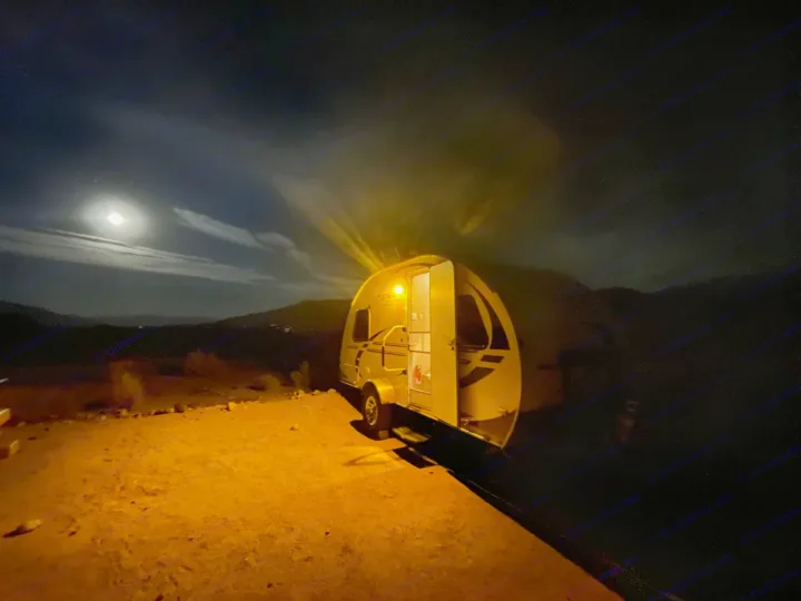 Experience an rv rental! A glowing compact RV is parked under the moon, casting warm light on the ground at night.. R-Pod R-Pod Trailer 2011