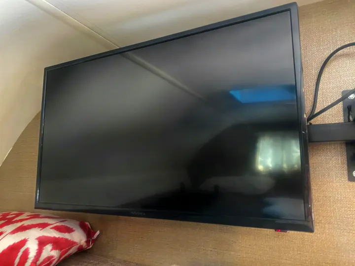 Dark Insignia TV mounted in an RV rental, reflecting the ceiling and room interior.. Winnebago Outlook 2019