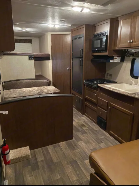 This RV rental's inviting interior features a well-equipped kitchen, cozy dinette, and convenient bunk beds.. Keystone Hideout 2016