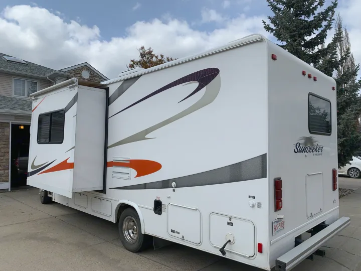 White Sunseeker RV with slide-out extended, parked on a driveway. Perfect for your next rv rental adventure!. Forester Forester Motorhome 2010