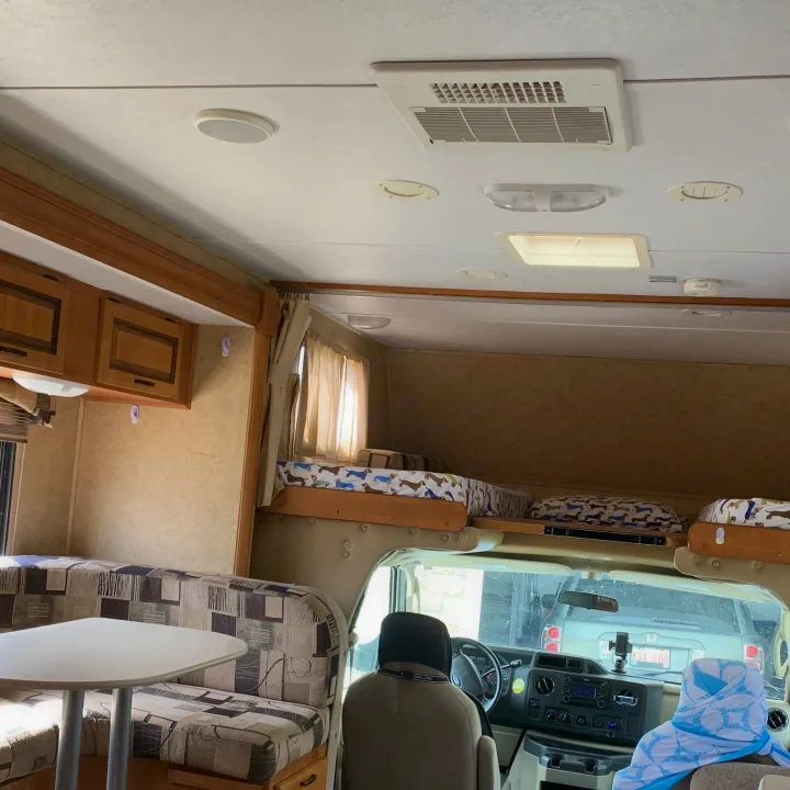 RV rental interior: dining nook, overhead bunk with dachshund bedding, and front cab view.. Forester Forester Motorhome 2010