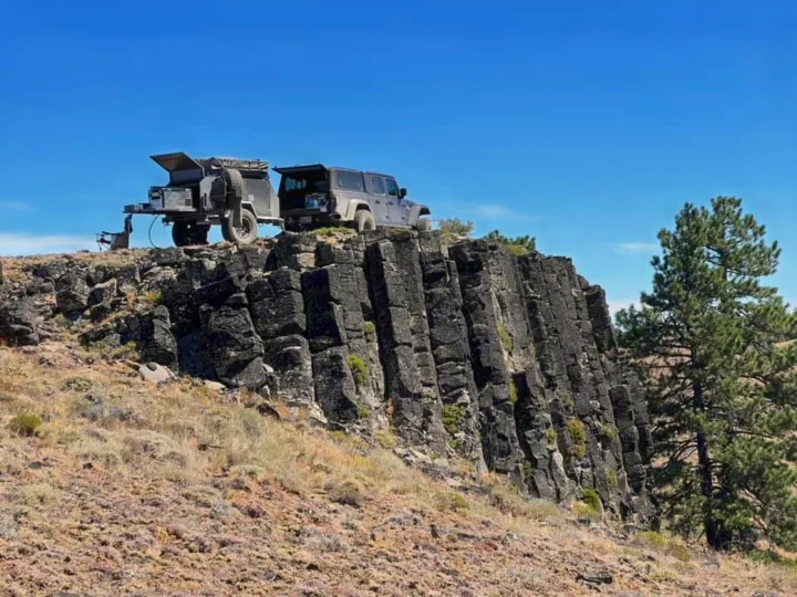 Explore remote cliffs with an RV rental! A Jeep Gladiator & off-road camper sit atop dramatic basalt columns under clear skies.. Vorsheer Vorsheer Trailer 2022