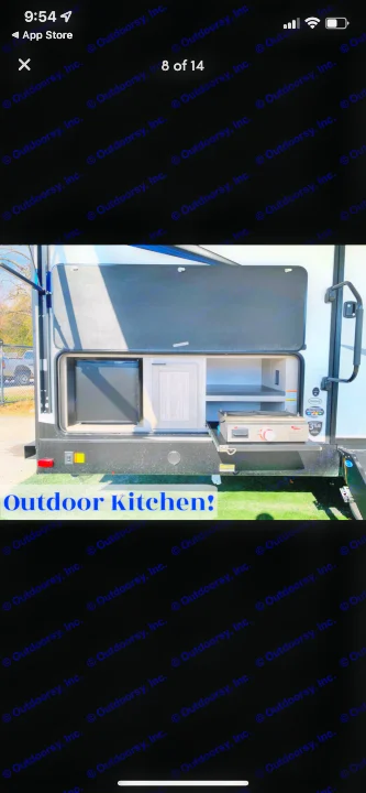 This RV rental features an outdoor kitchen setup, revealing a mini-fridge, pull-out stove, and storage compartments.. Shadow Trailers 277bhs 2022