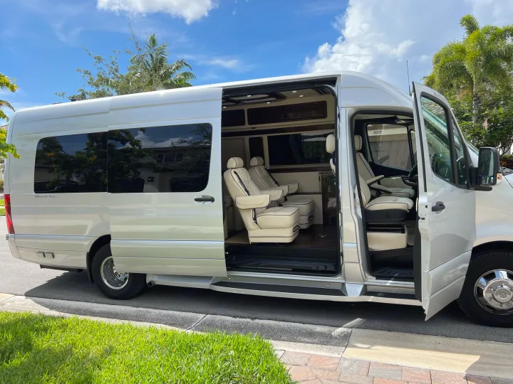 Luxury silver Mercedes Sprinter RV rental van. Open side door reveals a spacious, plush cream interior for travel.. Ultimate Toys Other 2022