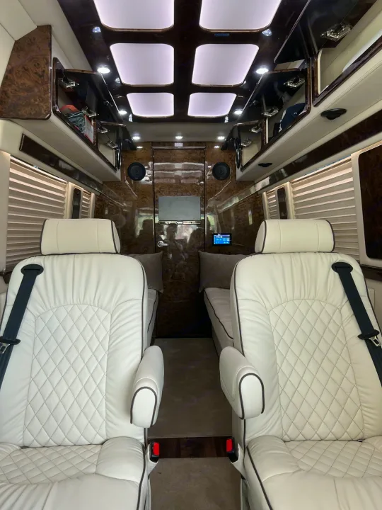 Luxury RV rental interior: white leather captain's chairs, elegant wood trim, custom lighting for comfortable travel.. Ultimate Toys Other 2022