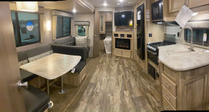 Modern RV rental interior: spacious dinette, well-equipped kitchen, and cozy living area with TV and fireplace.. Forest River Coachmen Catalina Legacy 2020