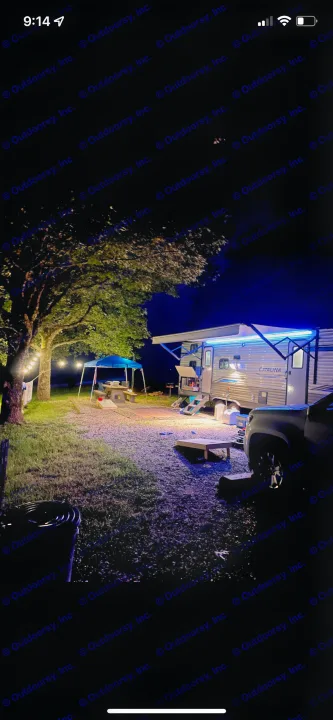 Illuminated night camping at a vibrant RV rental site! Features a glowing travel trailer, string lights, and a canopy for outdoor fun.. Forest River Coachmen Catalina Legacy 2020