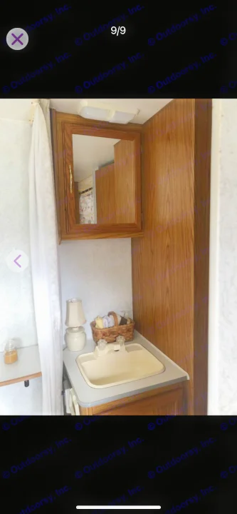 Compact RV rental bathroom with a vanity, sink, mirrored cabinet, and small lamp. Practical interior design for travel comfort.. Shasta Flite 2000