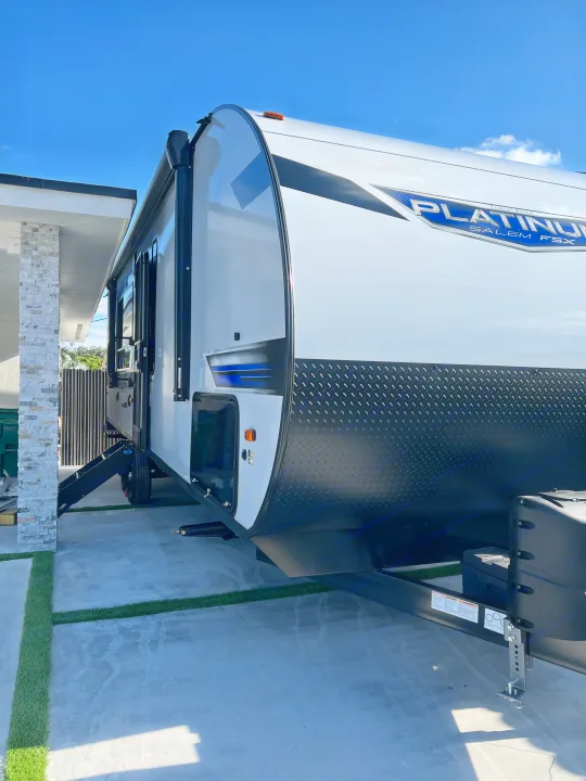Sleek white Platinum Salem FSX travel trailer (RV) with black diamond plate, available for rental, parked outdoors.. Forest River Salem FSX 270RTKX 2022
