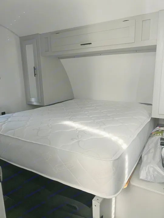Clean RV rental bedroom featuring a white Beautyrest mattress, overhead cabinets, and bright natural light.. Forest River Salem FSX 270RTKX 2022