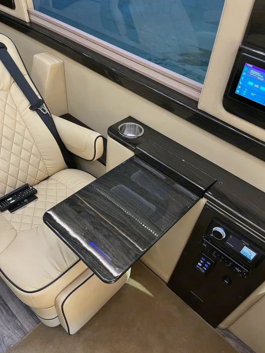 Luxury RV rental interior featuring plush seating, a sleek pull-out table, and modern control panel for comfort.. Midwest Automotive Designs Midwest Automotive Designs Class B 2021