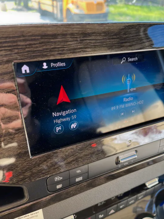 RV rental interior: Infotainment system displaying navigation for Highway 59 and 89.9 FM radio. Wood grain trim surrounds.. Midwest Automotive Designs Midwest Automotive Designs Class B 2021