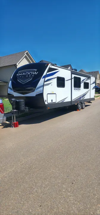 A sleek white and black Shadow Cruiser travel trailer, ideal for RV rental, is parked on a sunny street, ready for adventure.. Cruiser RV Shadow Cruiser 2022