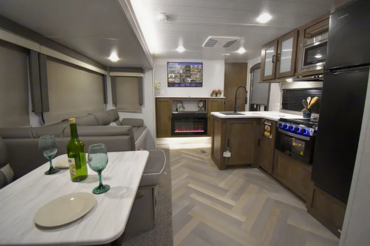 Inside a stylish RV rental: kitchen, living, and dining area with a fireplace. Enjoy comfort on the road!. Forest River Salem 2020