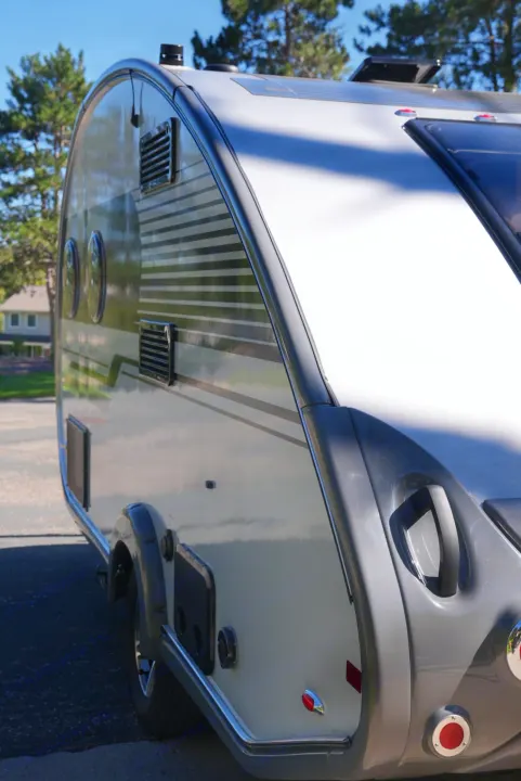 Close-up of a stylish light-colored travel trailer, ideal for an rv rental, showcasing its modern exterior and features.. Nucamp Tab 400 2022
